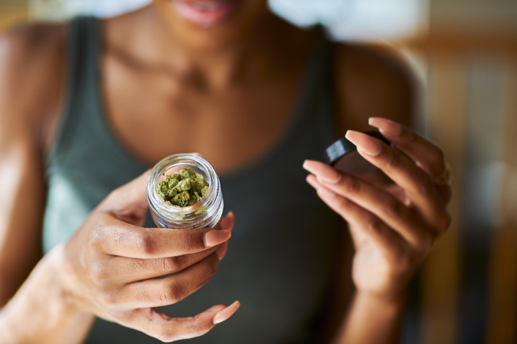 cannabis dosing woman holding out jar of bud